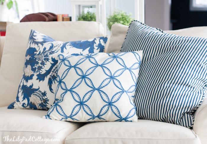 A white sofa with blue and white pillows