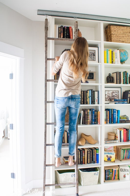 A person standing in front of a book shelf, with IKEA Billy Bookcase