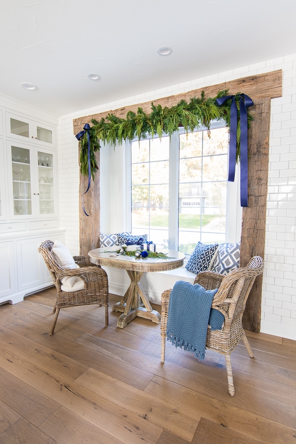 A breakfast nook with rustic beams and wicker chairs