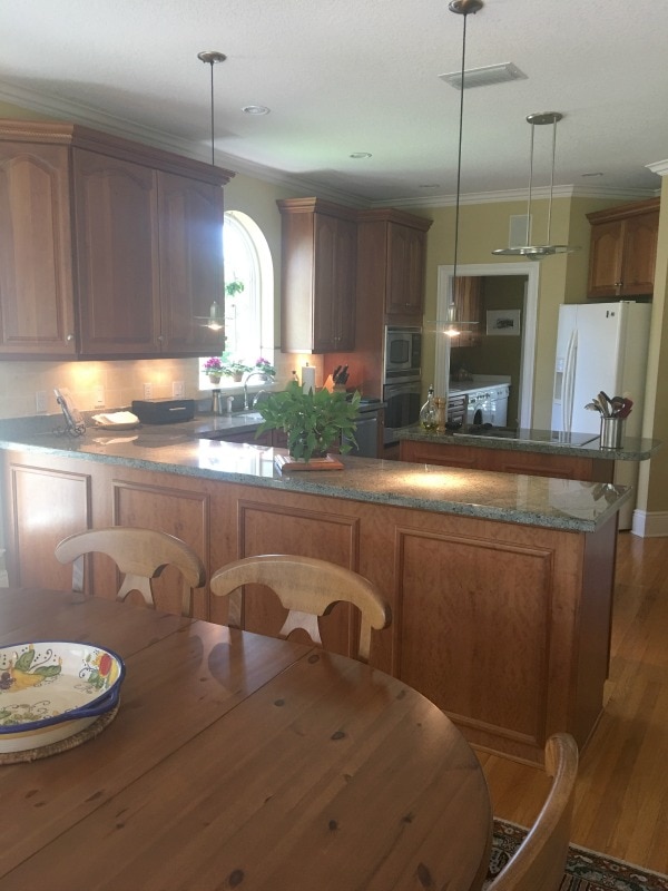 A kitchen with wooden cabinets and a dining table