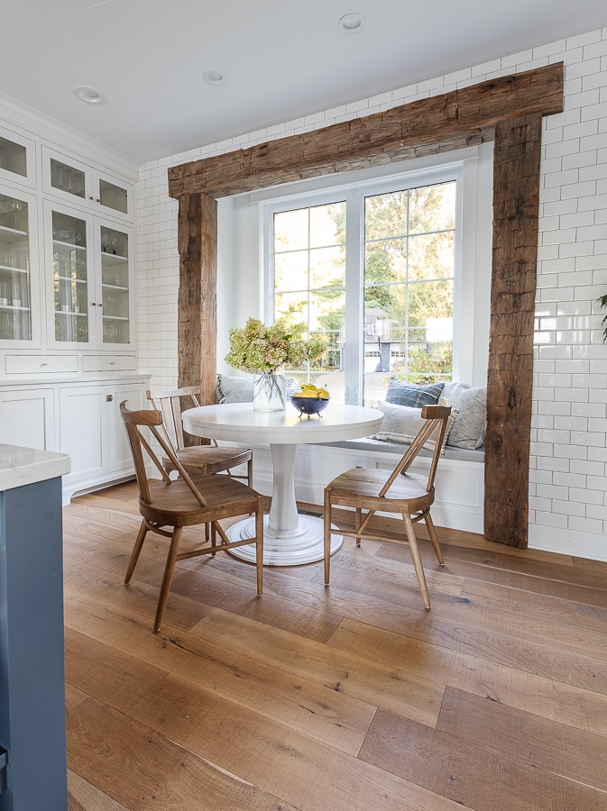 breakfast nook rustic beams white round table wood chairs