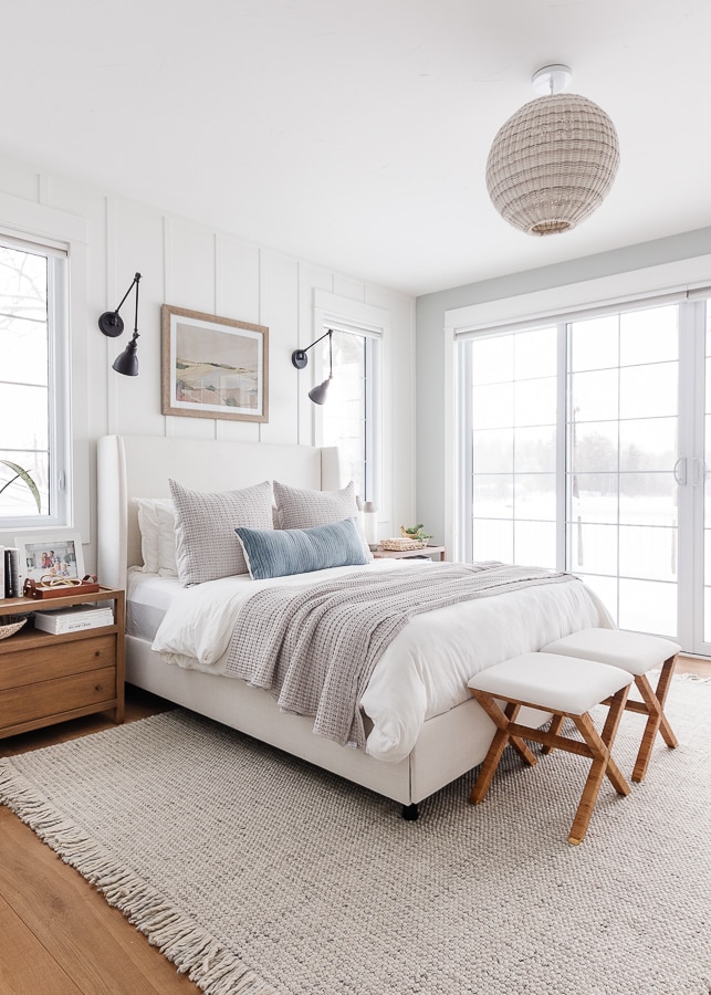 lake house bedroom. White walls, neutral bedding, warm wood floors.