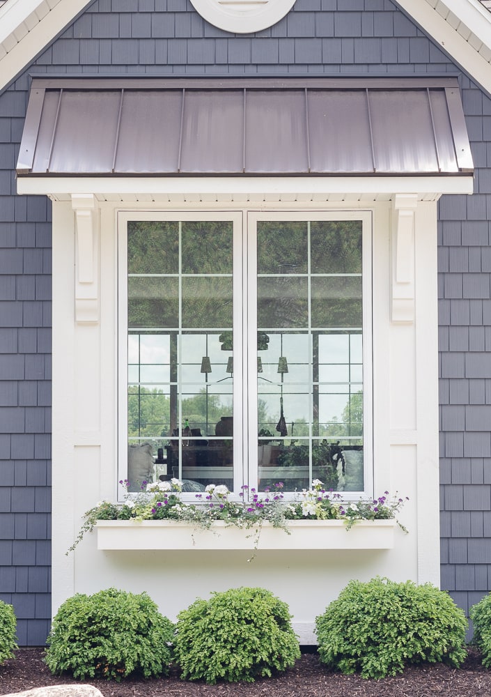 white and gray house with white window boxes