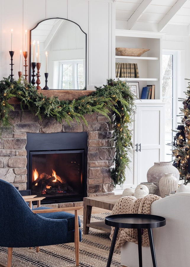 A fire place sitting in a living room filled with furniture decorated for Christmas