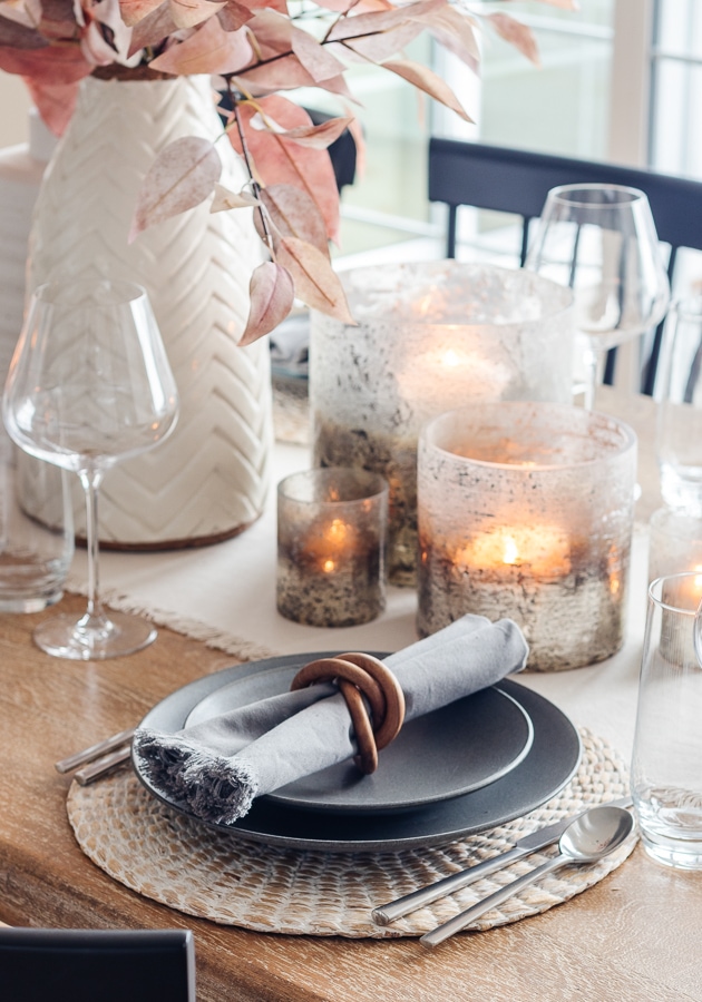 Dining table with linen runner and bronze candle holders 