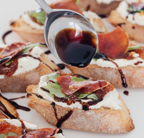 A plate of food with a slice cut out, with Crostini and Prosciutto