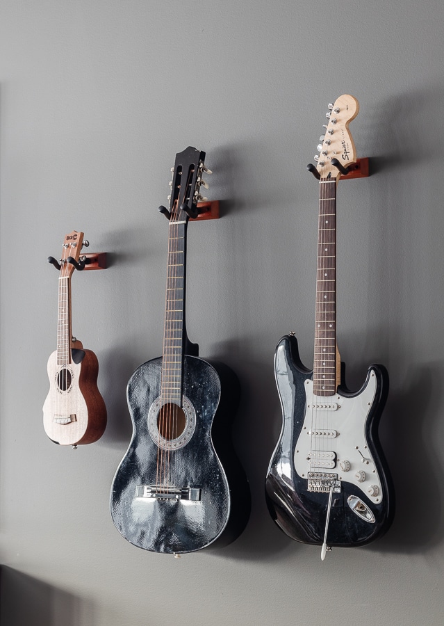 Dark gray walls with 3 hanging guitars
