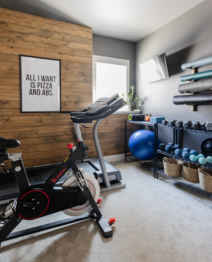 Home gym design with wood stained walls, Charcoal walls, and exercise equipment