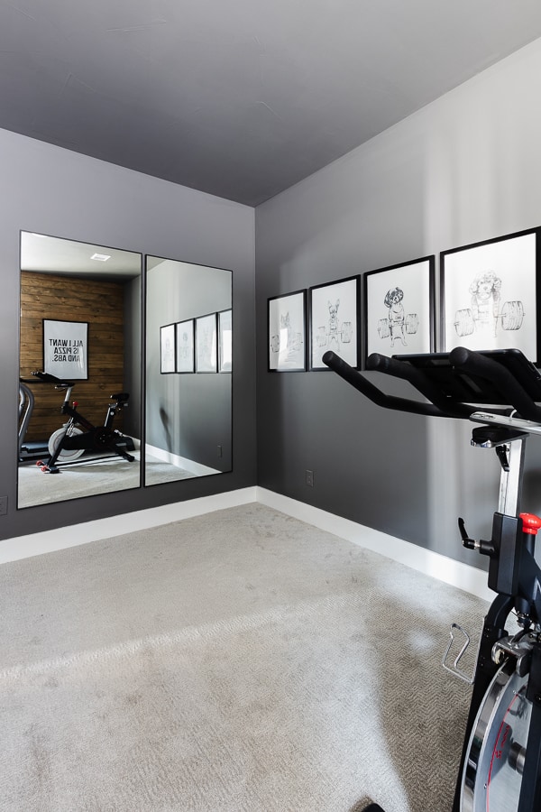 Home gym design with wood stained walls, Charcoal walls, and exercise equipment