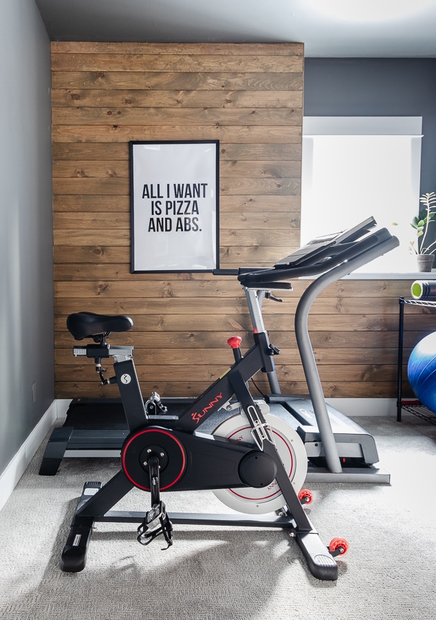 Home gym with stained wood walls and gray paint with exercise equipment