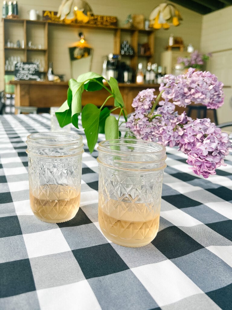 2 ball jars filled with wine on a table 