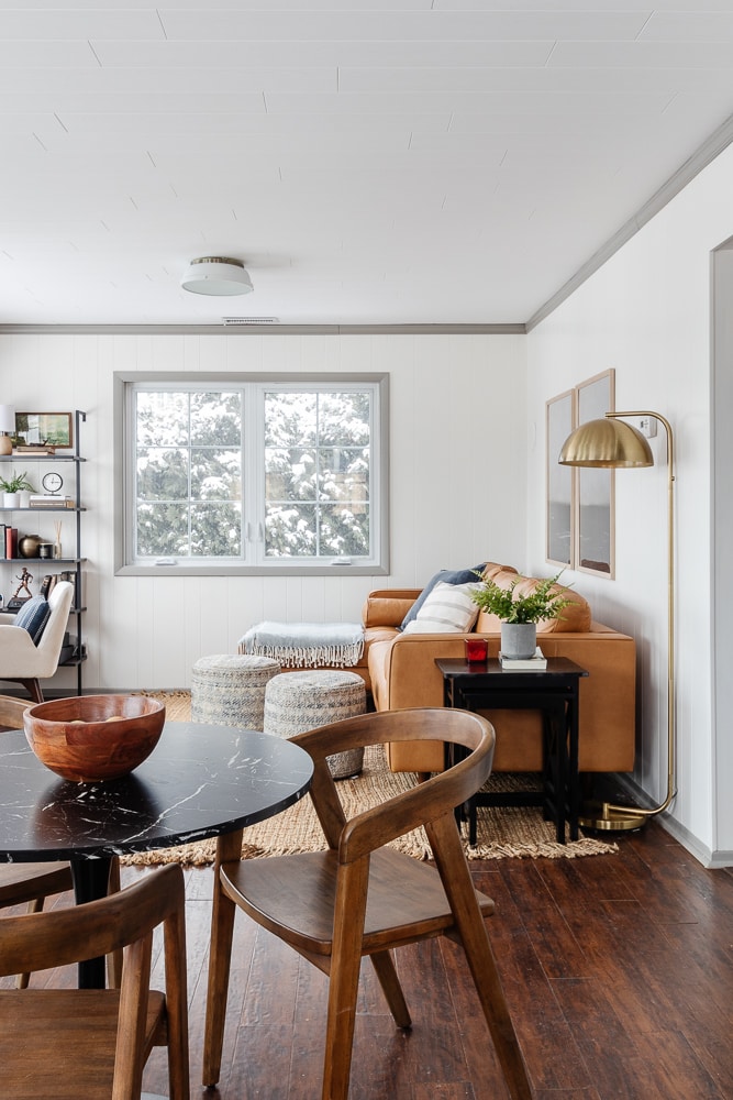 living room with white walls and planked ceilings with a leather sofa