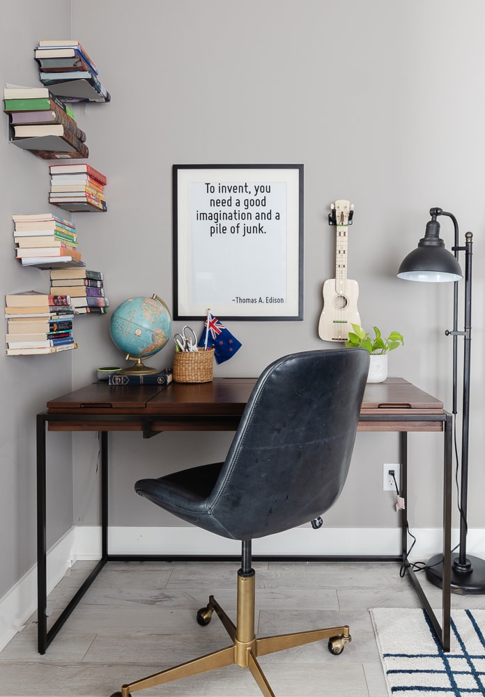 desk area with lamp and globe and wall art