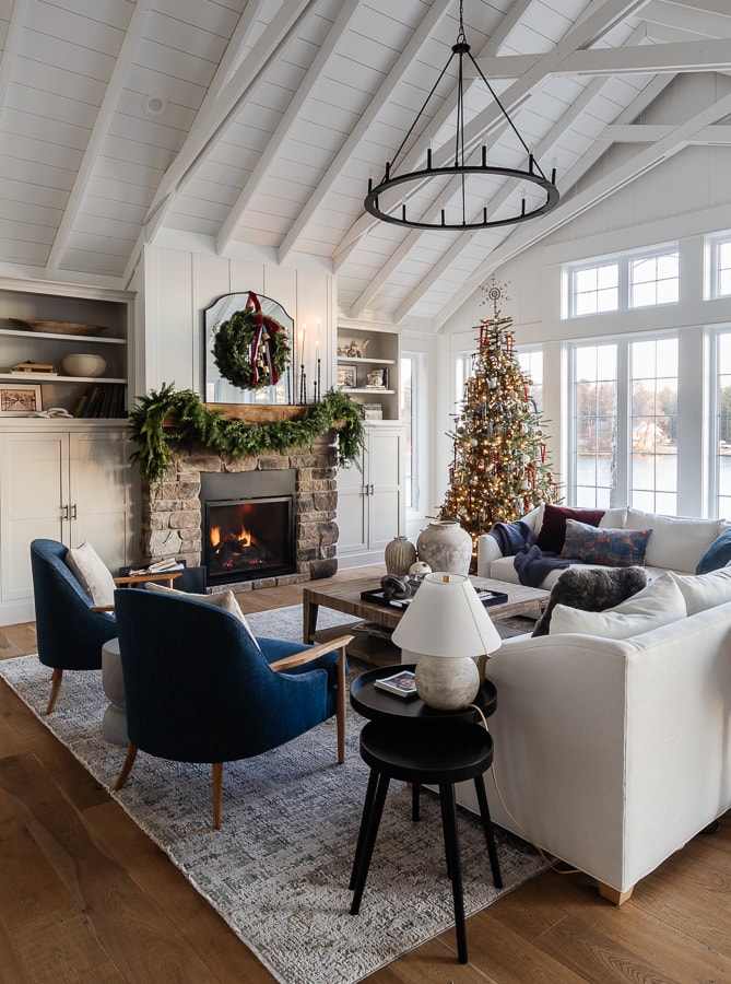 red and blue christmas decorations in a white walled living room with windows