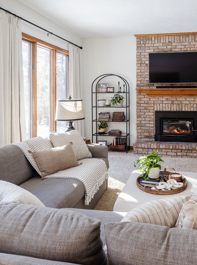 living room with white walls and brick fireplace