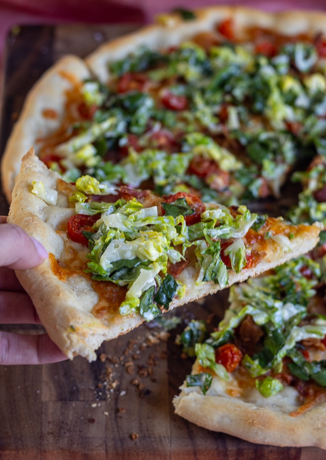 wood cutting board with pizza with bacon lettuce and tomato