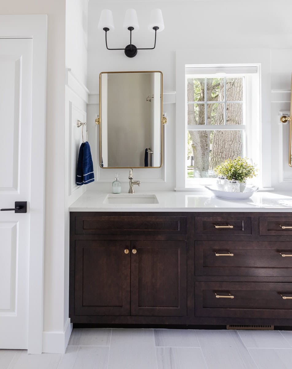 white bathroom with walnut cabinets and navy towels