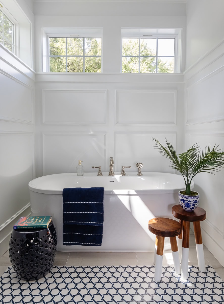 white tub with white walls and navy and white floor tiles
