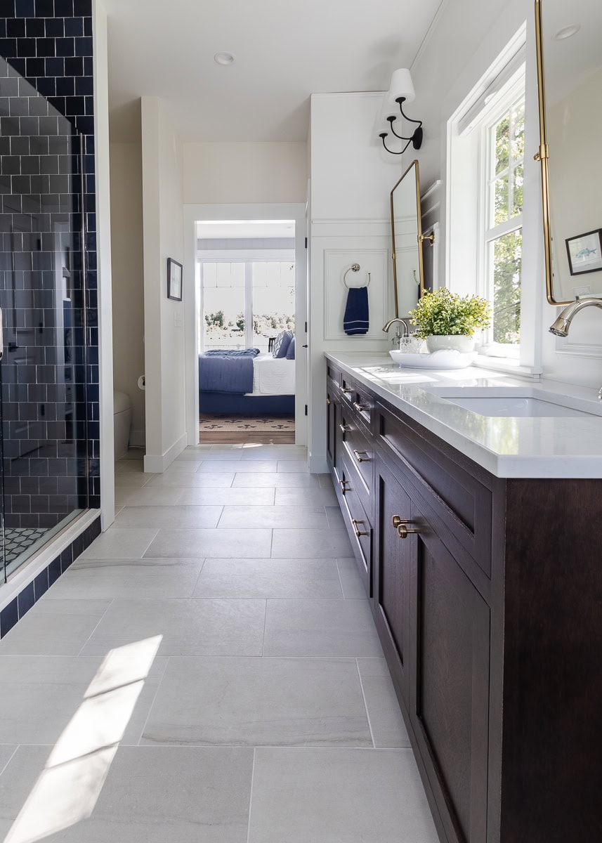 navy shower tile with walnut cabinets in a bathroom