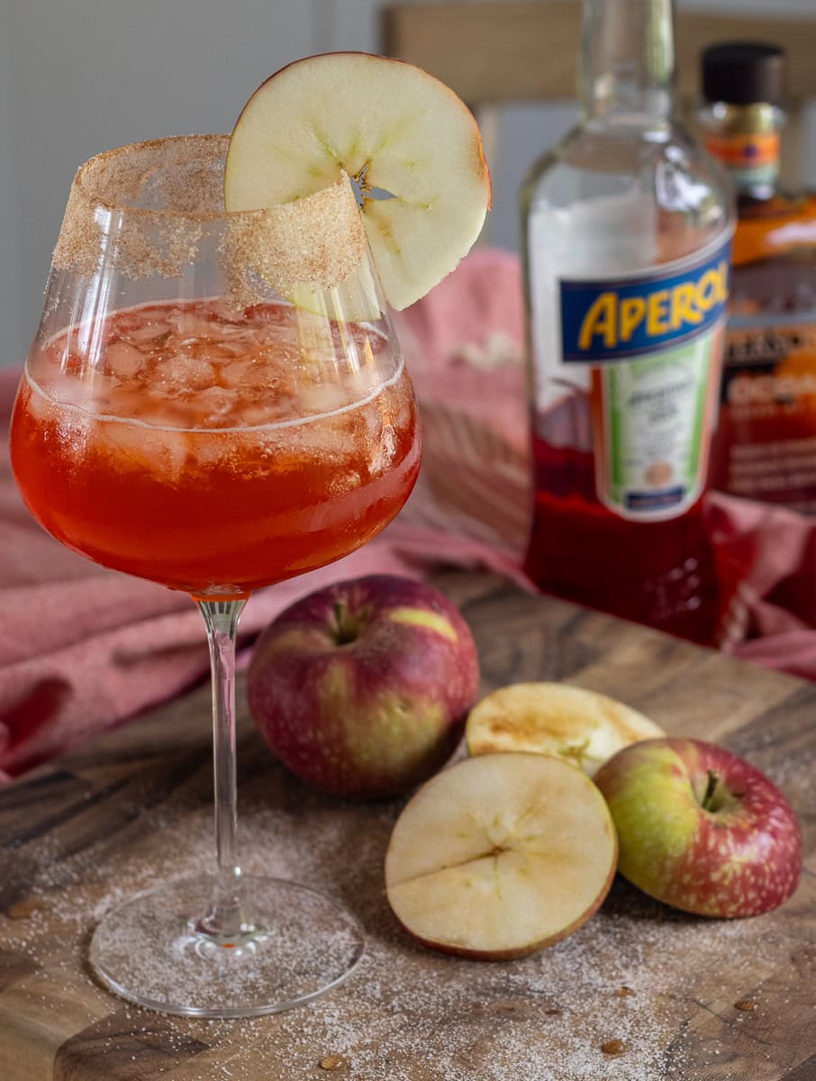 wine glass with aperol cocktail and apple garnish