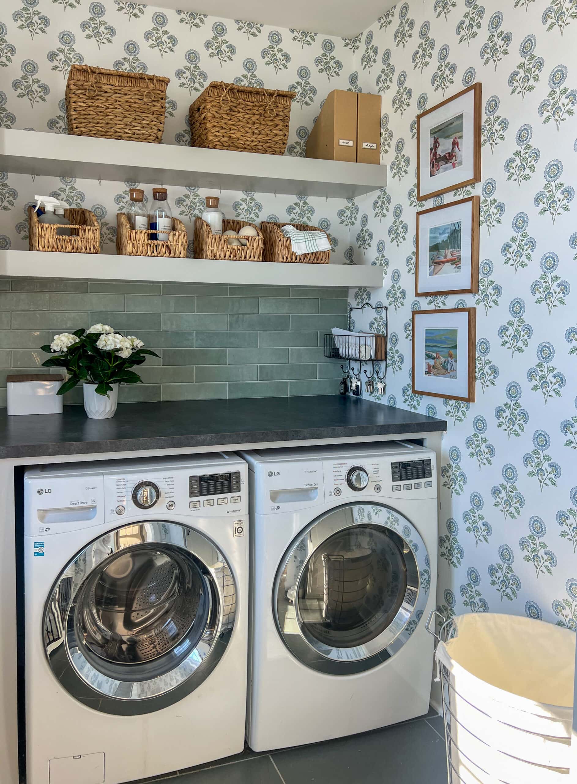 floral wallpapered laundry room with green tile and open shelves